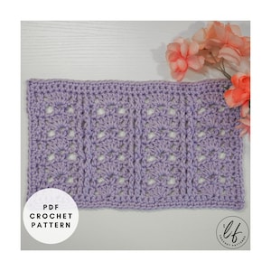 Może przedstawiać: Zbliżenie na fioletowy kwadrat wykonany na szydełku z powtarzającym się wzorem. Kwadrat leży na białym drewnianym tle z różowymi kwiatami w tle. Tekst "PDF CROCHET PATTERN" znajduje się w białym kółku po lewej stronie obrazu. Tekst "lf CROCHET PATTERNS" znajduje się w białym kółku po prawej stronie obrazu.