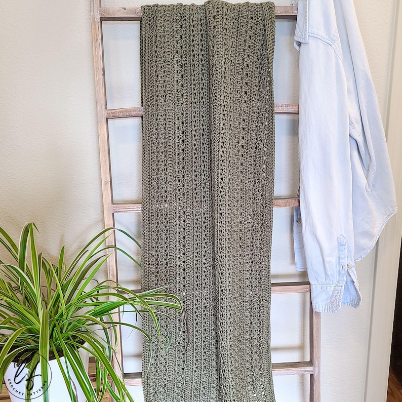 This image shows the crochet shawl pattern draped over a blanket ladder.