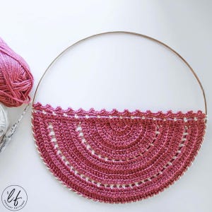 This image is a work in progress photo of this boho crochet wall hanging pattern, it has been attached to the hoop but does not have fringe added yet.