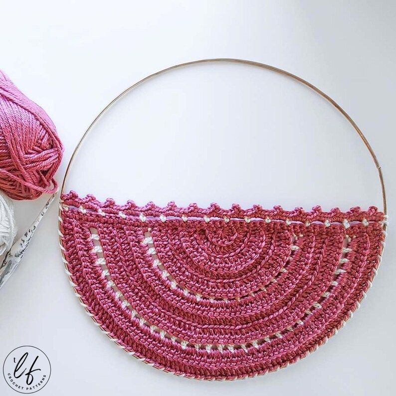 This image is a work in progress photo of this boho crochet wall hanging pattern, it has been attached to the hoop but does not have fringe added yet.