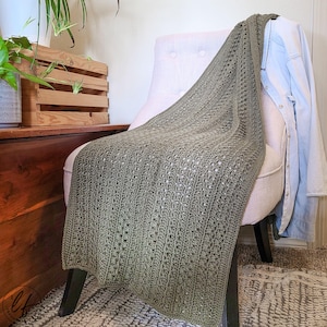 This image shows the crochet wrap pattern draped over a white fabric chair.