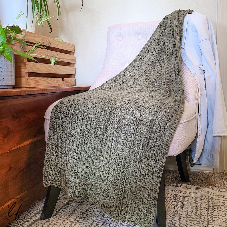This image shows the crochet wrap pattern draped over a white fabric chair.