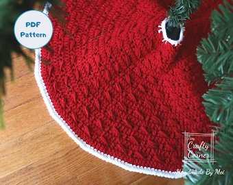 Può includere: Gonna per albero di Natale in crochet rosso con un bordo in crochet bianco. La gonna è realizzata con un punto a trama. Il testo "Tiny Crafty Corner Handmade By Mei" è visibile nell'angolo in basso a destra dell'immagine.