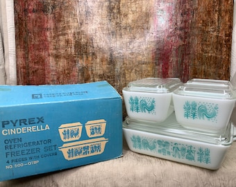 May include: Vintage Pyrex Cinderella oven, refrigerator, and freezer set. The set includes four pieces with covers, featuring a white base with a teal rooster and wheat design. The original blue box is also visible.