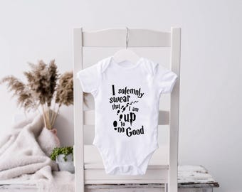 May include: White baby onesie with black text that reads "I solemnly swear that I am up to no good" with a graphic of footprints.