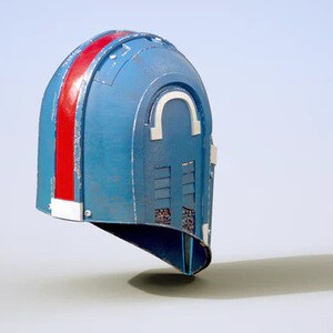 May include: A blue and red helmet with a white stripe and a series of small vents. The helmet has a rounded top and a pointed chin.