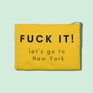 Könnte beinhalten: Gelbe Kosmetiktasche aus Canvas mit dem in Schwarz gedruckten Text "FUCK IT! let's go to New York".