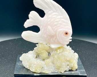 Genuine rose quartz handcrafted fish carving figurine, on a crystal quartz base.