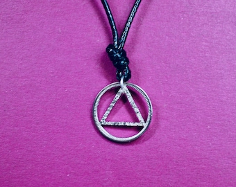 AA symbol pendant cut from a lucky sixpence.