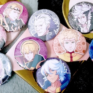 May include: Nine round button pins featuring different characters from a video game. The characters are depicted in a cartoon style with colorful backgrounds.