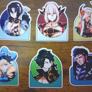 May include: Six colorful stickers featuring anime-style character portraits. Each sticker has a unique design with a white border and a background color. The characters have various hairstyles and outfits, with a fantasy theme.
