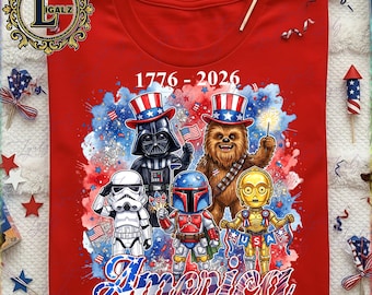 May include: Red t-shirt featuring a graphic of Star Wars characters in patriotic attire, including Darth Vader and Chewbacca, celebrating America's 250th Anniversary. The design includes the text "America" and the years "1776-2026".