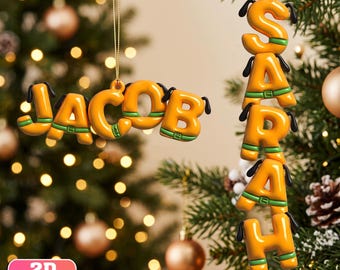 May include: Two custom Christmas ornaments featuring yellow, bubble-style letters with black dog ears and green collars. One ornament displays the name JACOB horizontally, while the other displays the name SARAH vertically. Both are 2D flat hanging decorations.