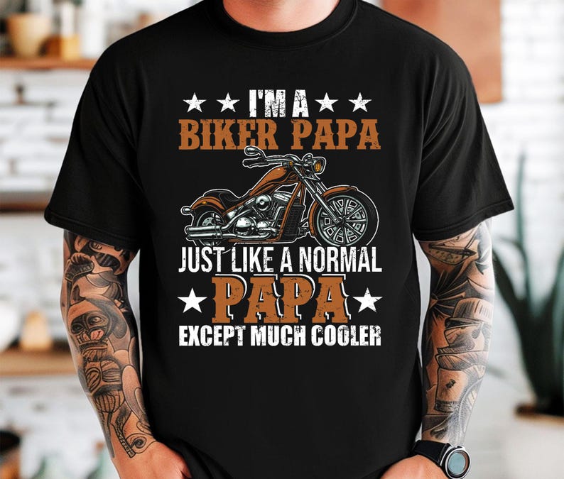 Puede incluir: Camiseta negra con un dise&ntilde;o gr&aacute;fico blanco que presenta una motocicleta y el texto "Soy un pap&aacute; motorista como un pap&aacute; normal, excepto mucho m&aacute;s genial".