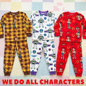 May include: Three sets of long-sleeve pajamas featuring Toy Story characters. The first set is yellow and brown plaid with Woody graphics. The second is white with Buzz Lightyear prints. The third is red with Jessie graphics and horseshoe patterns.