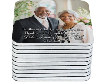 May include: A stack of square coasters featuring a photograph of an older couple. The image includes text that reads "Together in Christ, stronger every day. Thank you for 10 wonderful years! Pastor David & Lily Rath 07.25.26."