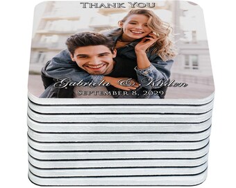 May include: A stack of square coasters featuring a photograph of a smiling couple. The coasters have rounded corners and the text "THANK YOU" at the top. The names "Gabriela & Kaden" and the date "SEPTEMBER 8, 2029" are also printed on the coasters.