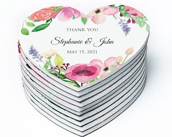 May include: A stack of heart-shaped wedding favor magnets with a watercolor floral design. The magnets feature the text "Thank You Stephanie & John May 15, 2021".