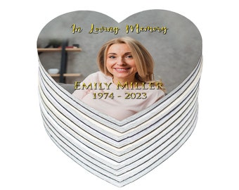 May include: A stack of heart-shaped memorial coasters with a photo of a woman and the text "In loving memory Emily Miller 1974 - 2023".