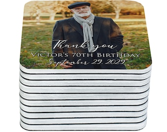 May include: A stack of 12 square coasters with a photo of a man in a black jacket and a scarf. The text on the coaster reads "Thank you, Victor's 70th Birthday, September 29, 2029".