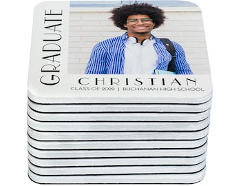 May include: A stack of square white coasters with black trim. The top coaster features a photo of a young man smiling and wearing a blue plaid shirt. The text "GRADUATE" is on the left side of the coaster and "CHRISTIAN CLASS OF 2029 | BUCHANAN HIGH SCHOOL" is on the bottom.
