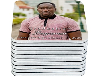 May include: A stack of square coasters with a photo of a person in a pink polo shirt. The text on the coaster reads "Graduation Benjamin Parkview High School 2029".