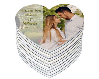 May include: Heart-shaped wedding favor with a photo of a couple and the text "Thank You Alexa & Charles June 2, 2029." The favor has a striped edge in shades of gray and white.