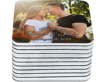May include: A stack of square coasters featuring a photograph of a couple. The image includes the text "Thank you Lauren & Justin August 16, 2029" in a script font. The coasters have a white top and black edges.