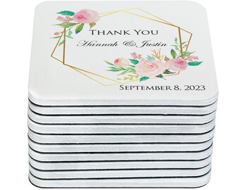 May include: A stack of 12 white square coasters with a gold geometric frame and pink floral design. The text "Thank You Hannah & Justin September 8, 2023" is printed on the coasters.