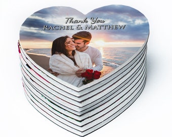 May include: A stack of heart-shaped magnets with a photo of a couple on a beach at sunset. The text "Thank You Rachel & Matthew" is printed on the magnet.