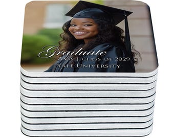 May include: A stack of square coasters with a photo of a graduate wearing a black cap and gown. The text on the coaster reads "Graduate Ava | Class of 2029 Yale University".