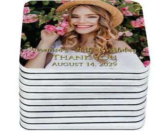 May include: A stack of square coasters with a photo of a young woman smiling in a floral setting. The text "Veronica's 20th Birthday Thank You August 14, 2029" is printed in gold on the coaster.