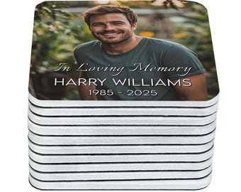 May include: A stack of square coasters featuring a photograph of a smiling person in a green shirt. The text "In Loving Memory" and the name "HARRY WILLIAMS 1985 - 2025" are printed on the coasters. The coasters have white edges.
