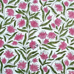 May include: White fabric with a repeating floral pattern. Pink flowers with green leaves and stems are printed across the surface. The design has a hand-drawn aesthetic, with the flowers and leaves outlined in a darker shade.