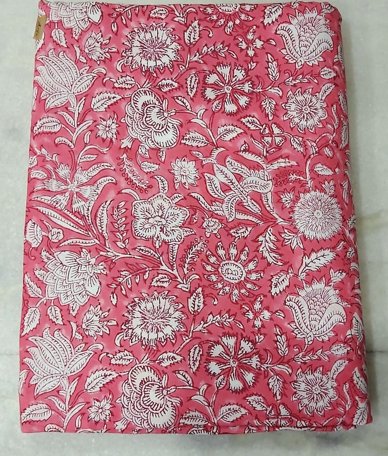 K&ouml;nnte beinhalten: Rosafarbener Stoff mit wei&szlig;em Blumendruck. Der Stoff hat ein traditionelles indisches Design mit filigranen Details.