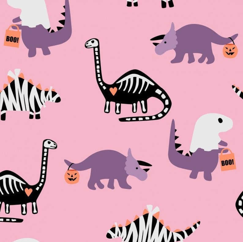 May include: A pink background with a repeating pattern of dinosaurs dressed up for Halloween. There are dinosaurs wearing ghost costumes, skeleton dinosaurs, and dinosaurs carrying trick-or-treat bags. The text "Boo!" appears on some of the bags.