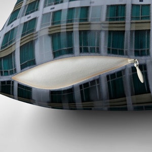 May include: A close-up of a building with numerous windows. The windows are all of the same size and shape, and they are arranged in a grid pattern. The windows are made of glass, and they are reflecting the sky.