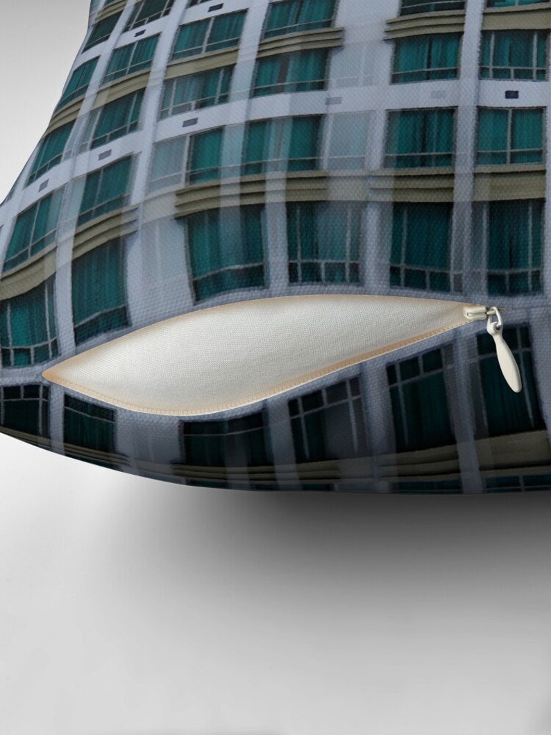 May include: A close-up of a building with numerous windows. The windows are all of the same size and shape, and they are arranged in a grid pattern. The windows are made of glass, and they are reflecting the sky.