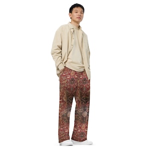May include: A person wearing a beige button-down shirt and red, patterned pants. The pants have a detailed design that resembles a rug.
