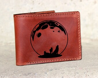 May include: A brown leather wallet with a design of a full moon and three wolves howling at the moon.