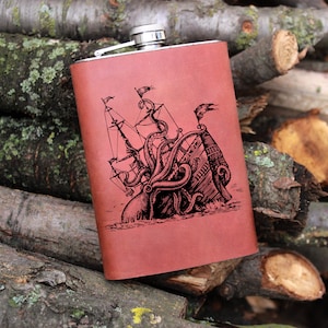 May include: A brown leather-wrapped flask with a silver top. The flask features an engraved image of an octopus attacking a ship.