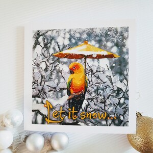 Deja que nieve divertido saludo de feliz Navidad tarjeta en blanco loro con paraguas