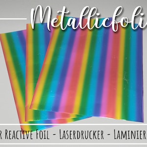 Op de afbeelding: Drie vellen regenboogkleurige metallicfolie, met het label "Metallicfolie - Toner Reactive Foil - Laserdrucker - Laminiergerät".