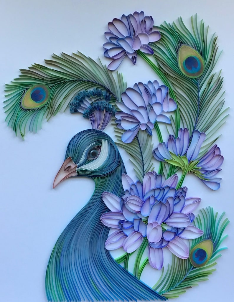Op de afbeelding: Een pauw gemaakt van papierquilling met blauwe en groene veren. De pauw is omringd door paarse bloemen met groene stelen.