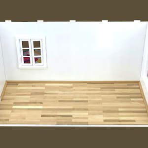 K&ouml;nnte beinhalten: Ein wei&szlig;er Puppenhausraum mit Holzboden, einer wei&szlig;en T&uuml;r und zwei Fenstern. Ein Fenster hat ein buntes gemustertes Stoffst&uuml;ck im Inneren.
