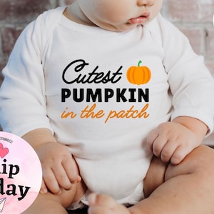 May include: White long-sleeve baby onesie with the text "Cutest Pumpkin in the patch" in black lettering and an orange pumpkin graphic.
