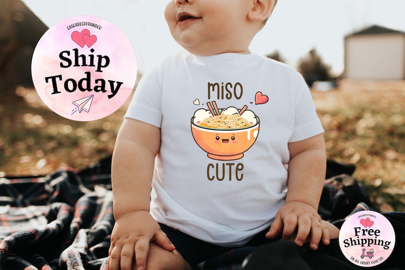 May include: White baby onesie with a cartoon illustration of a bowl of miso ramen with the text "miso cute".