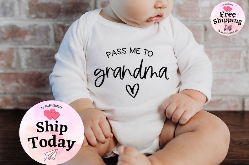 May include: White long-sleeve baby onesie with black text that reads "Pass me to grandma" with a small heart.