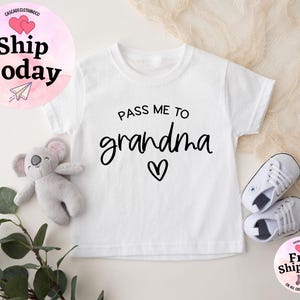 May include: White baby onesie with black text that reads "Pass me to grandma" with a small heart symbol.