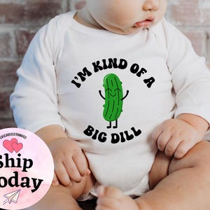 May include: White long-sleeve baby onesie with a green cartoon pickle and the text "I'm kind of a big dill".